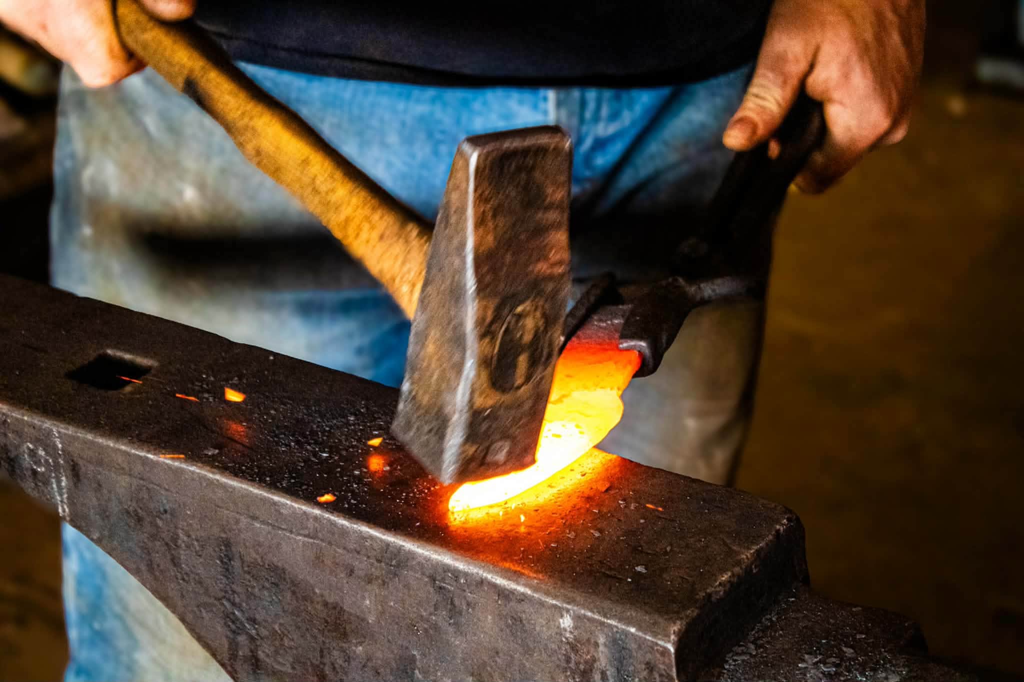 Hammer striking hot steel on the anvil